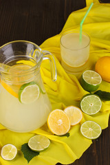 Citrus lemonade in glass and pitcher of citrus around