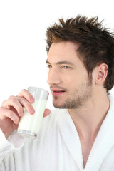 Man in bathrobe drinking milk