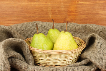 Ripe pears in sack on wooden background close-up