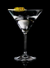 Martini glass and olives on grey background
