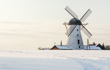 Old white windmill in Estonia at snowy winter day