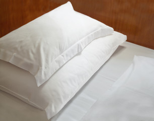 Fototapeta na wymiar Białe poduszki na drewnianym łóżku