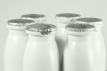 bottle with foil cap with yogurt, halfbody