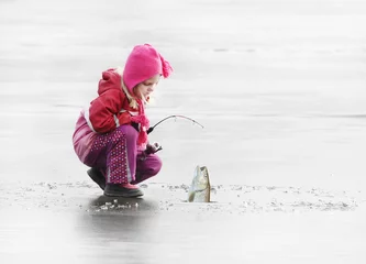 Poster Little child fishing on a frozen lake in winter. © Kletr