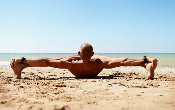 Man in strong stretching yoga pose