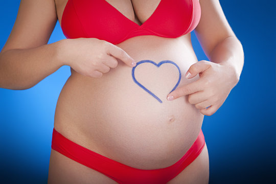 pregnant woman with the drawn heart on a belly