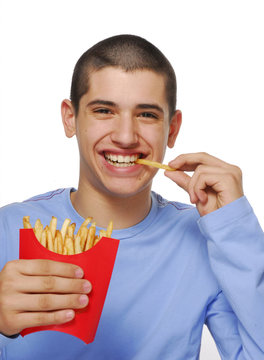 Niño contento comiendo patatas fritas,papas fritas.