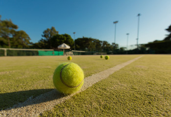 Tennis ball on a line of a green tennis court