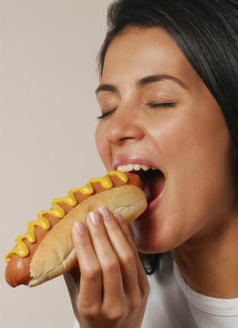 Mujer comiendo perro caliente,comida r&aacute;pida.