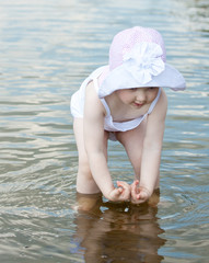 Cute little girl playing in water