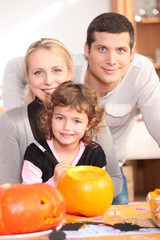 Fototapeta na wymiar Dziewczynka z rodziców przygotowujących dynię na Halloween