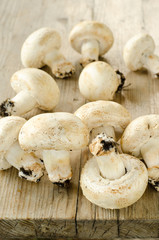 Funghi champignon su tavolo in legno invecchiato