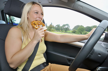 Autofahrerin isst beim Autofahren