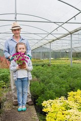 Little girl holding flower pot standing with her granddad