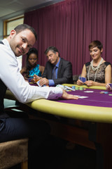 Smiling dealer at poker game