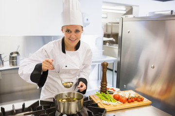 Woman tasting soup while cooking