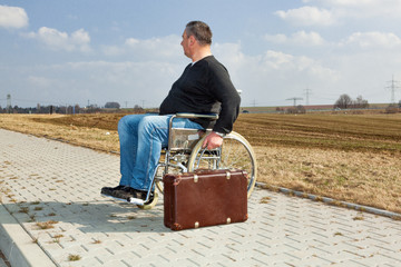 Man with suitcase wheelchair and walk on the road