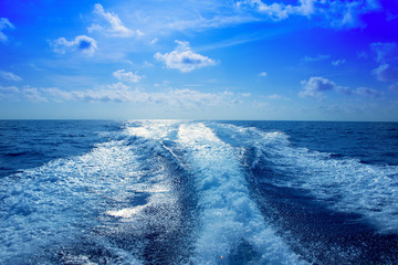 Boat wake prop wash foam in blue sky