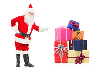 Full length portrait of a smiling Santa Claus offering presents