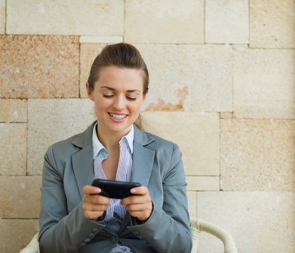 Happy Business Woman Writing Text Message On Cell Pone