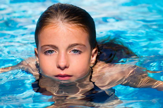 blue eyes kid girl at the pool face in water surface