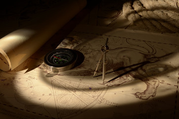 Old compass, calipers and rope on vintage map