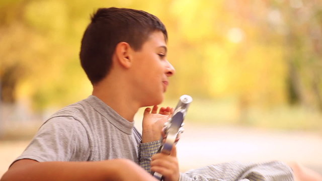 teen playing with his brother on a background of autumn alley
