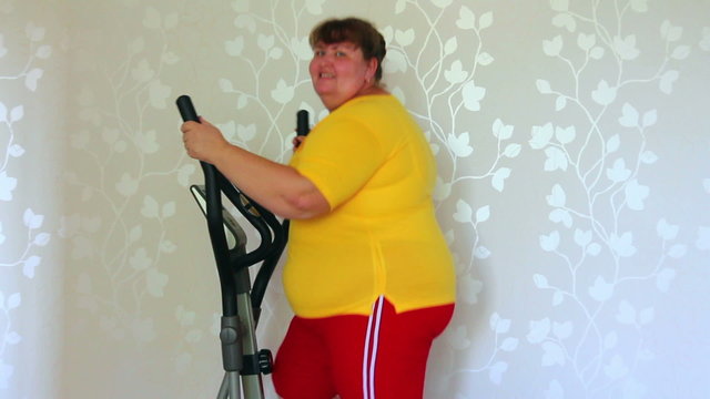 overweight woman exercising on trainer ellipsoid