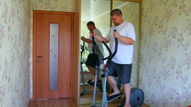 overweight man exercising on trainer ellipsoid