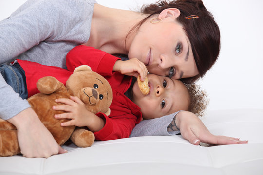 Mother and her adopted son laying on the bed.
