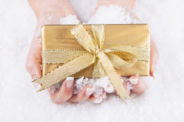 Ein goldenes Geschenk in der Hand
