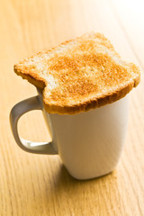 Toasted bread placed on the coffee mug.