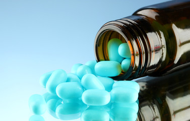 pills in bottle, on blue background