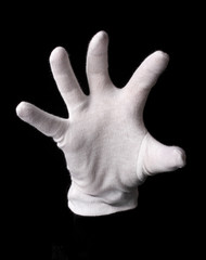 Hand in white glove making sign isolated on black