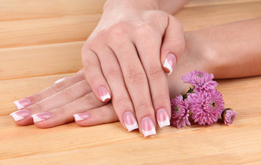 Fototapeta premium Woman hands with french manicure and flowers
