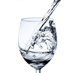 Pouring water into glass isolated on white