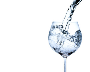 Pouring water into glass isolated on white