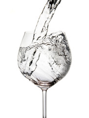 Pouring water into glass isolated on white
