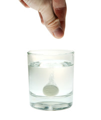 Effervescent tablet splashing into glass full of water