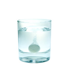 Effervescent tablet splashing into glass full of water