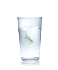 Effervescent tablet splashing into glass full of water