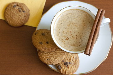 Cappuccino with chocolate cookies on wooden table
