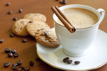 Cappuccino with chocolate cookies on wooden table