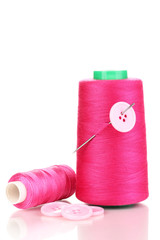 Pink bobbin with needle and buttons isolated on white