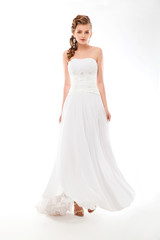 Fototapeta na wymiar Beautiful woman in wedding dress over studio background