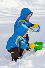 Fototapeta na wymiar One-year-old twins play in snow