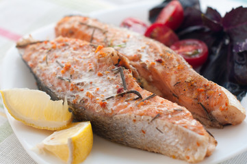 salmon steak with cherry tomatoes basil and lemon