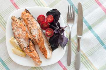 salmon steak with cherry tomatoes basil and lemon