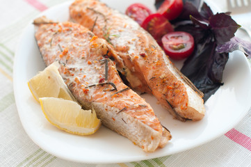 salmon steak with cherry tomatoes basil and lemon