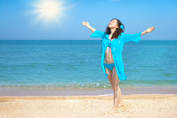 Happy young girl on the beach enjoying summer sun